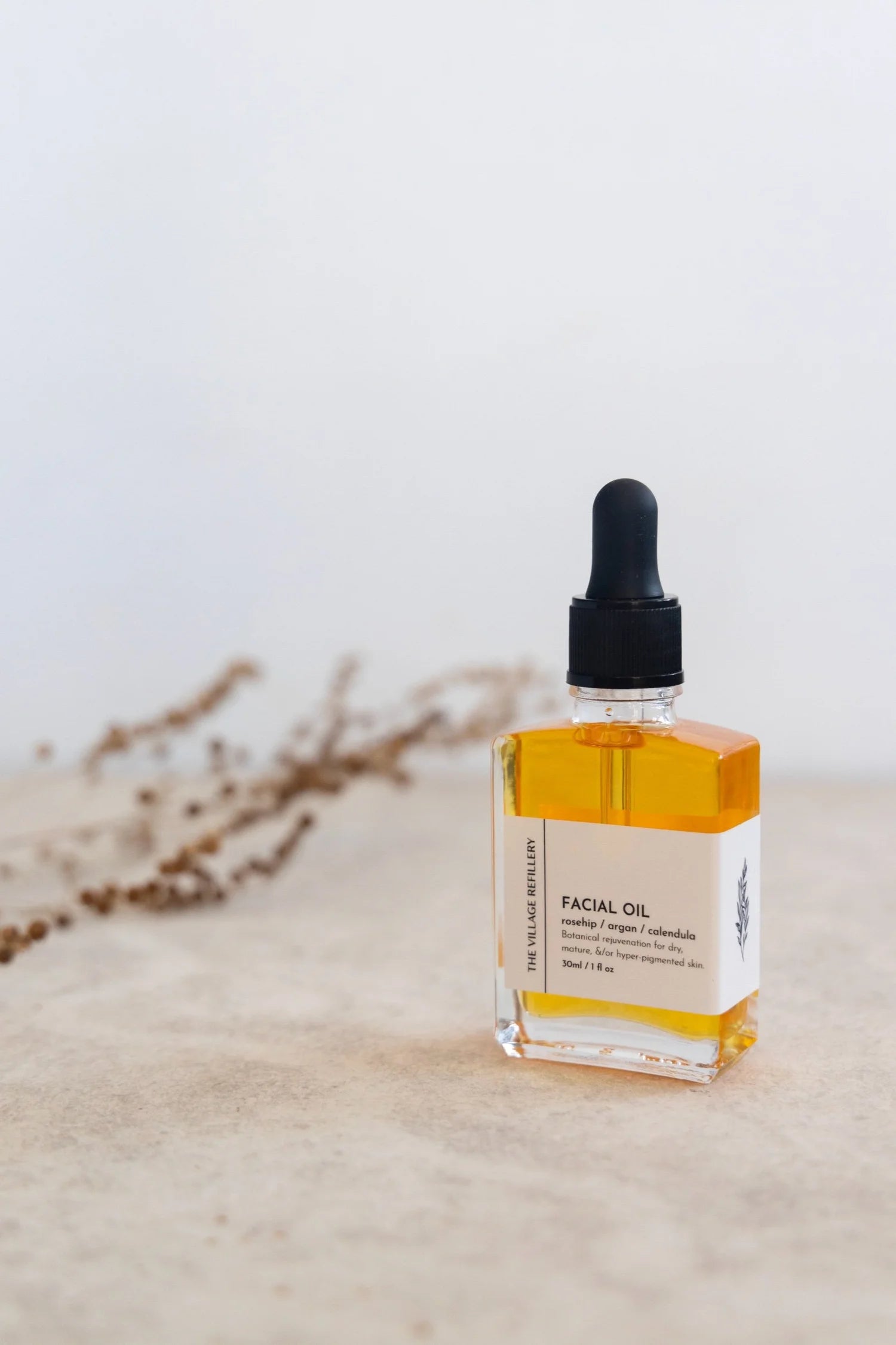 The Village Refillery VR Face Oil body care product showing a sleek glass bottle with dropper for nourishing body oil application.