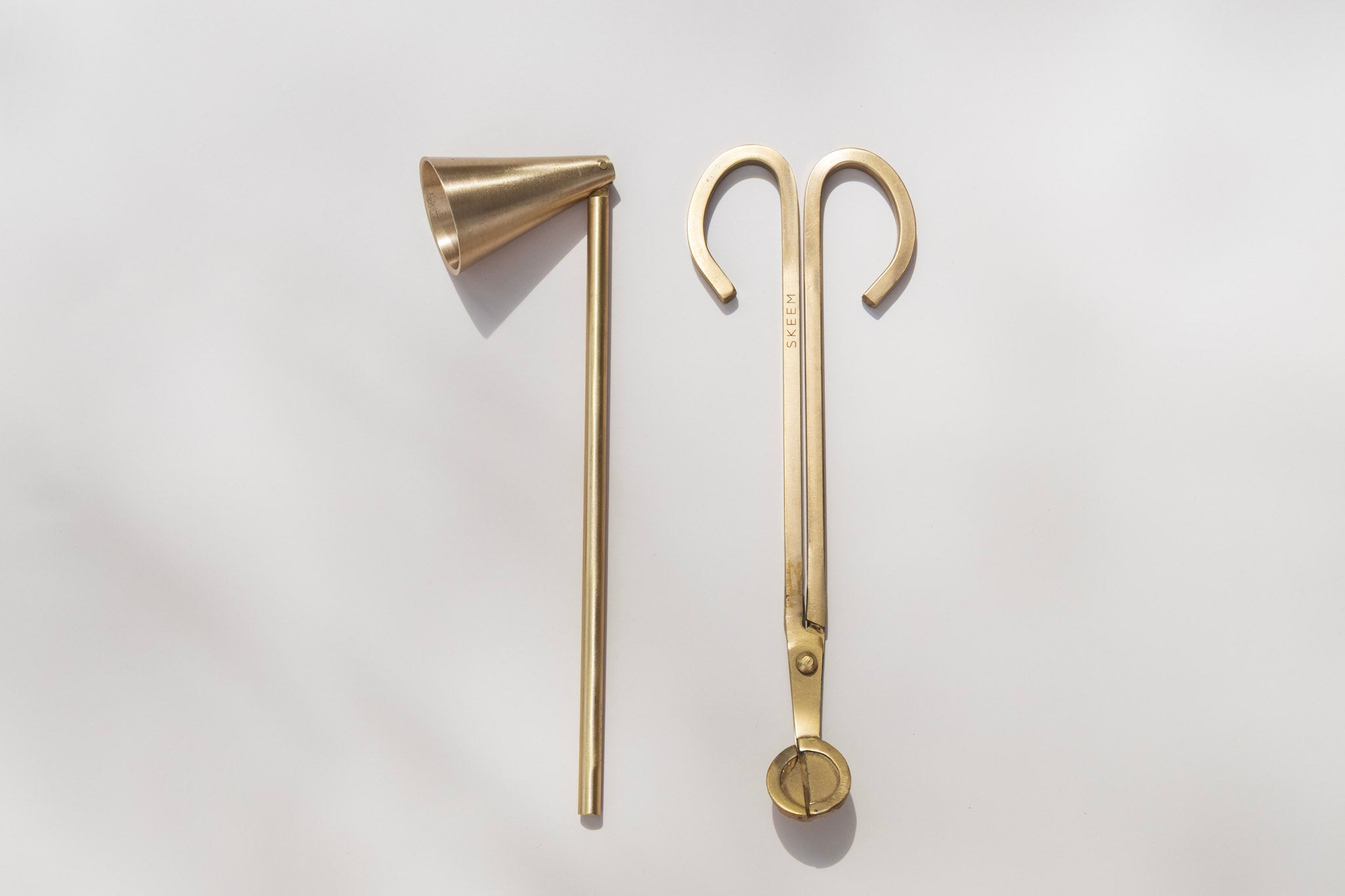 Matte gold candle wick trimmer and snuffer set from Skeem, styled on a neutral background