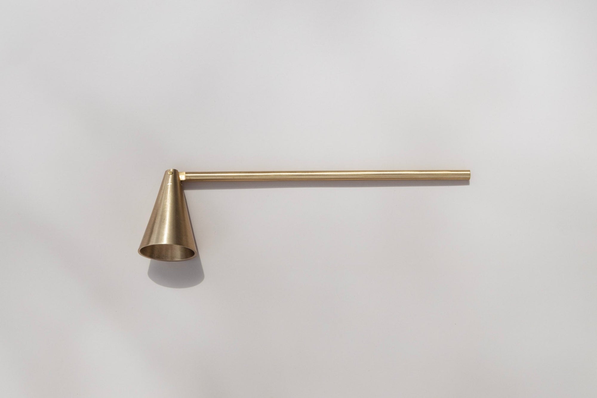 Skeem matte gold candle snuffer with long handle designed for effortless candle extinguishing