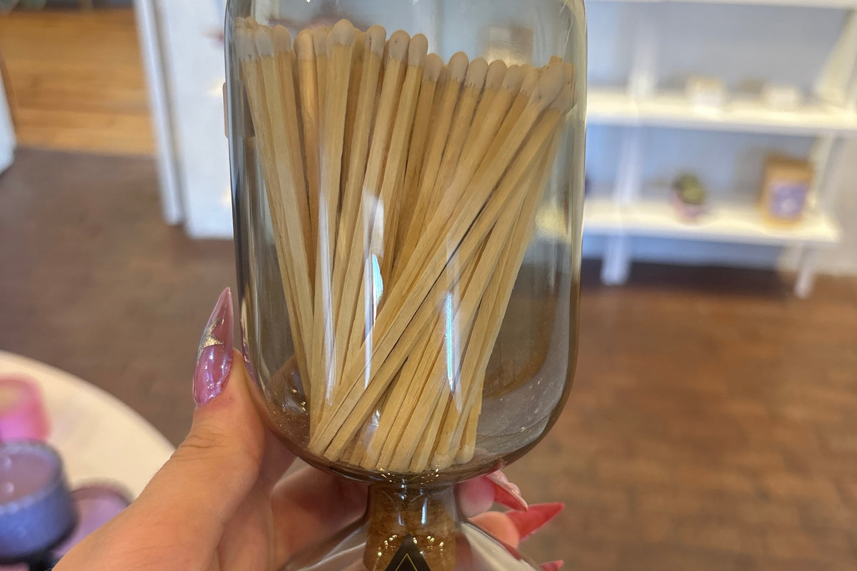 SKEEM glass match cloche with candles and matches inside, showcasing a clear glass dome covering candles and matchstick holder.
