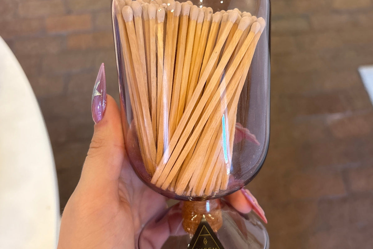 SKEEM glass match cloche covering a set of matchsticks for candles, elegant clear glass container with a minimalist design.