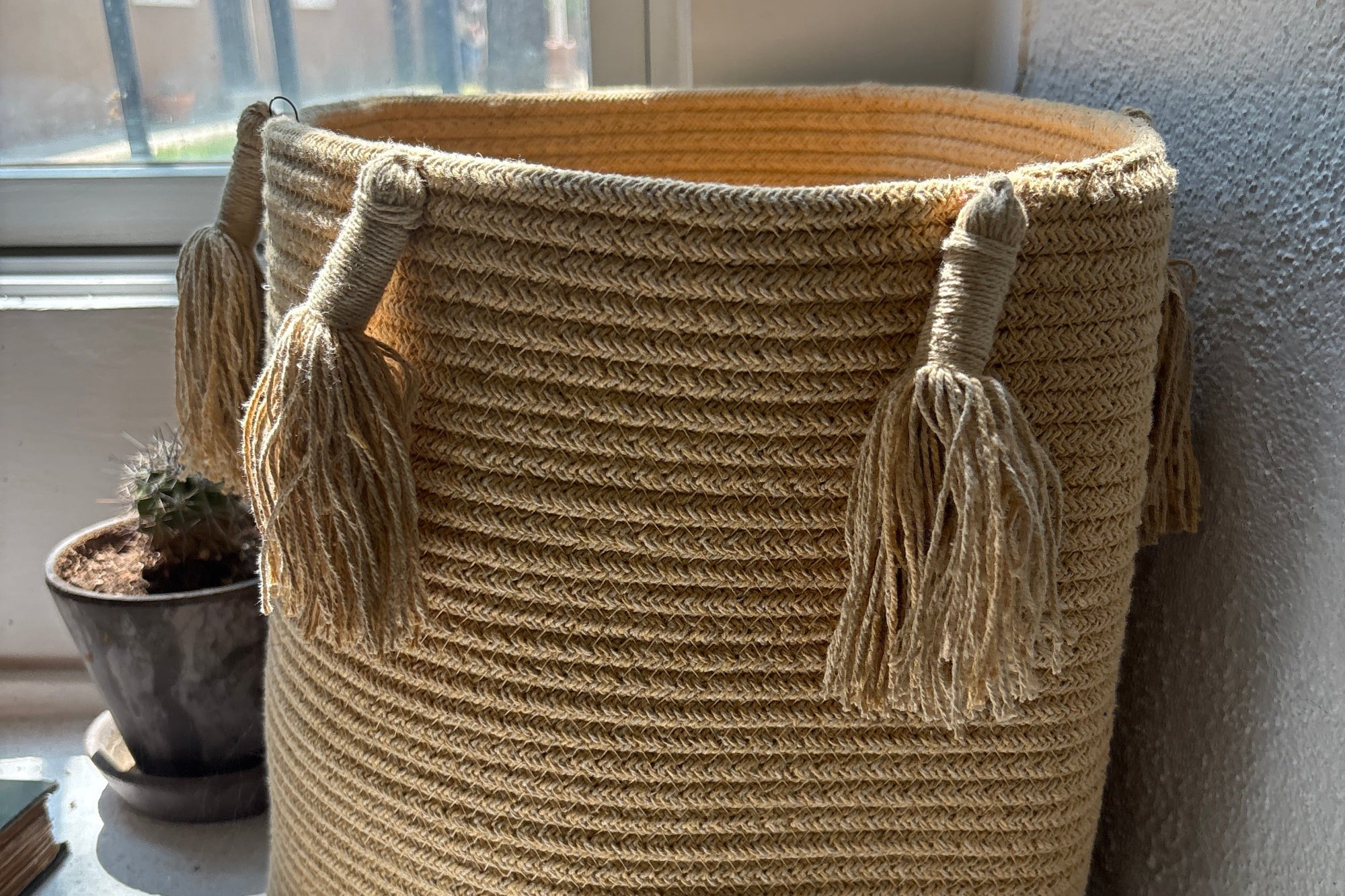Woven basket with tassels on a windowsill
