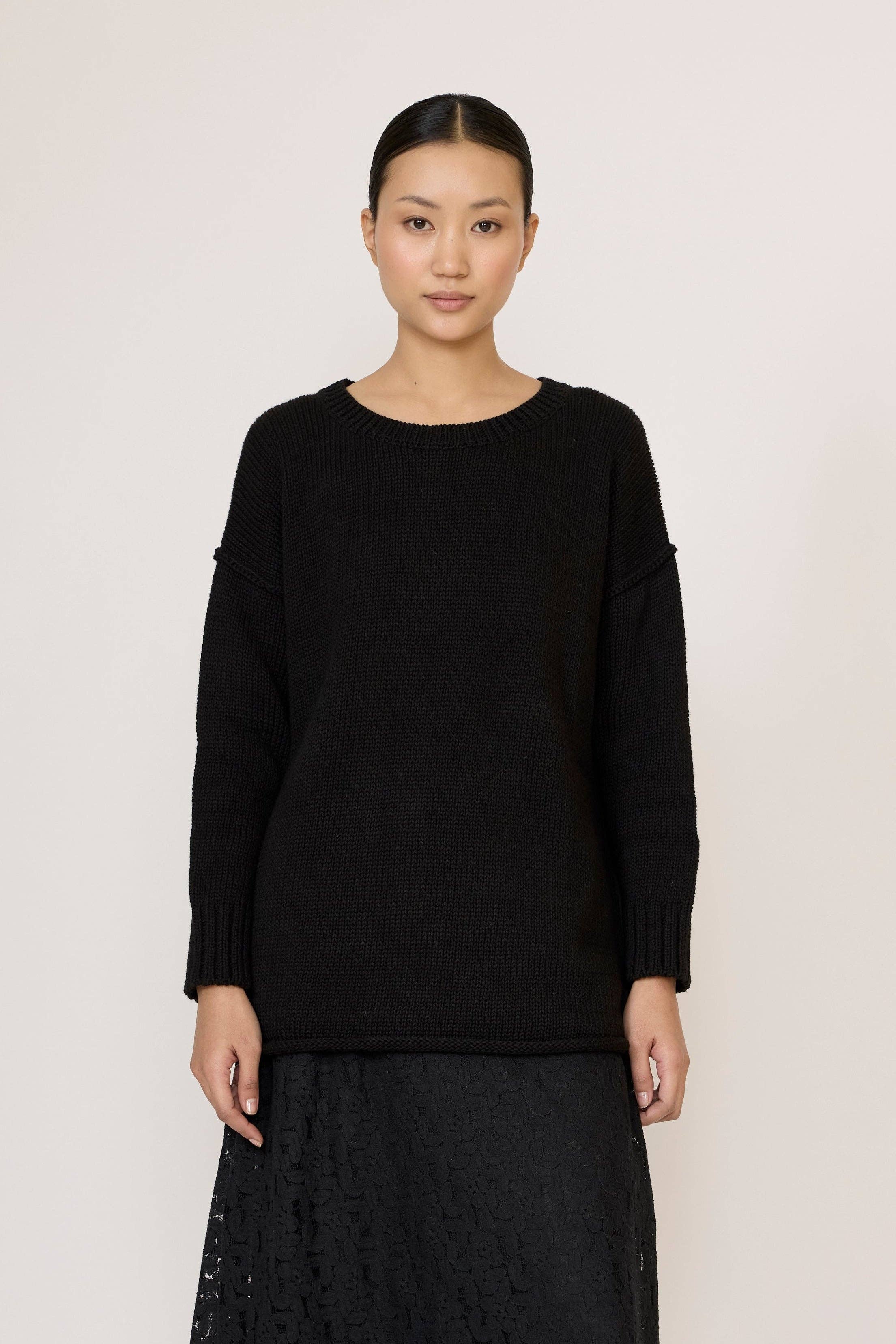 Black oversized crewneck sweater by LAUDE, showing a cozy, relaxed fit with ribbed cuffs and neckline.