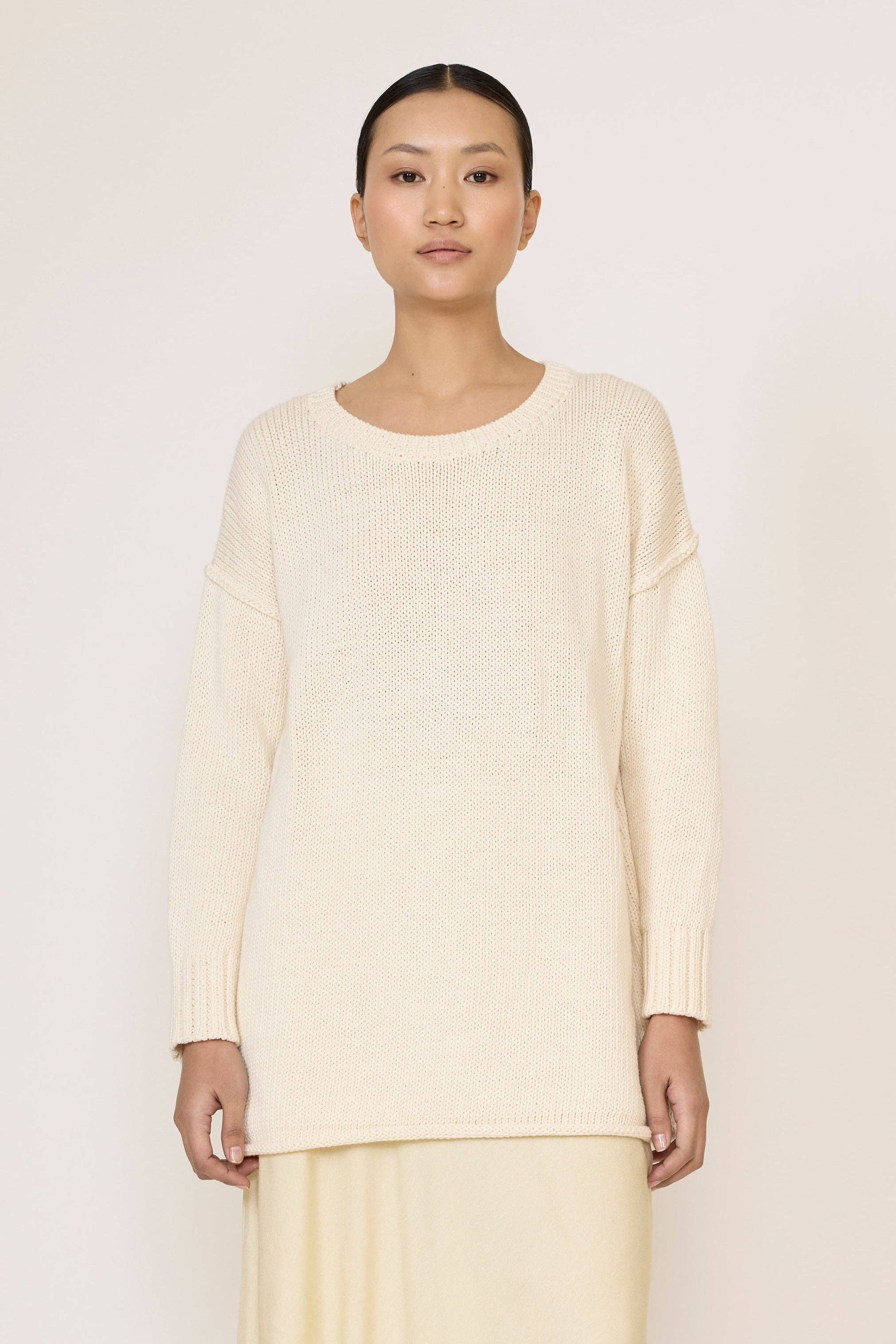 Ivory oversized crewneck sweater by LAUDE, showing a soft, chunky knit fabric with a relaxed fit and ribbed collar.