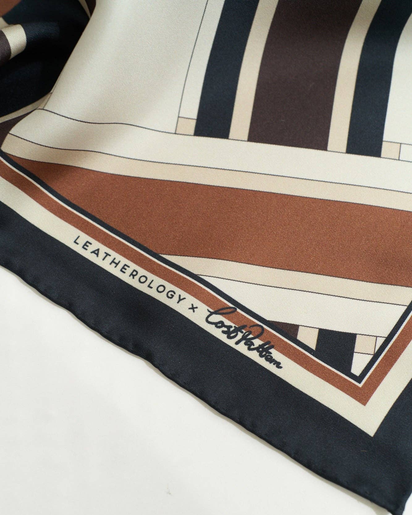 Lost Pattern NYC Leatherology silk square scarf in neutral tones, featuring a stylish pattern and soft, luxurious fabric.