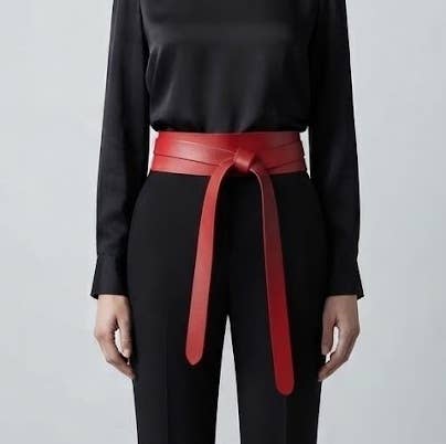 Red adjustable leather wrap belt from ADA Collection Belts, styled with a sleek, modern design and metal buckle.