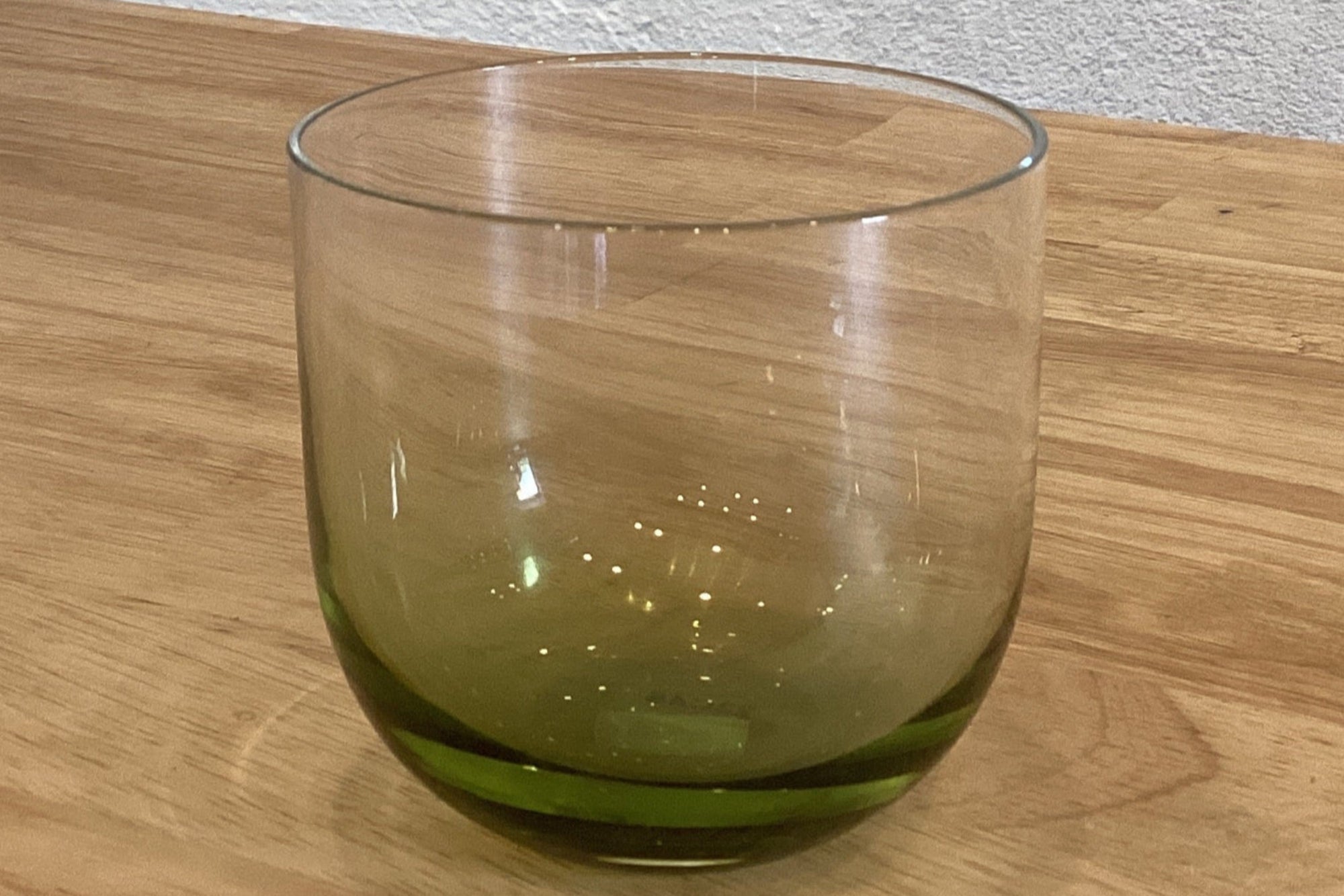 Clear glass with green tint on a wooden surface