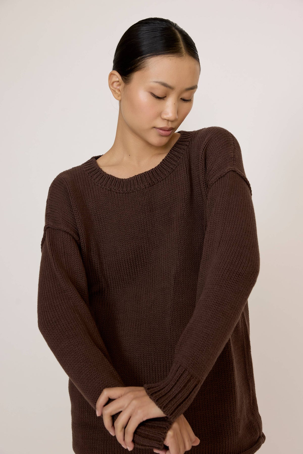LAUDE oversized chocolate crewneck sweater displayed on a mannequin, showcasing its relaxed fit and soft knit fabric.