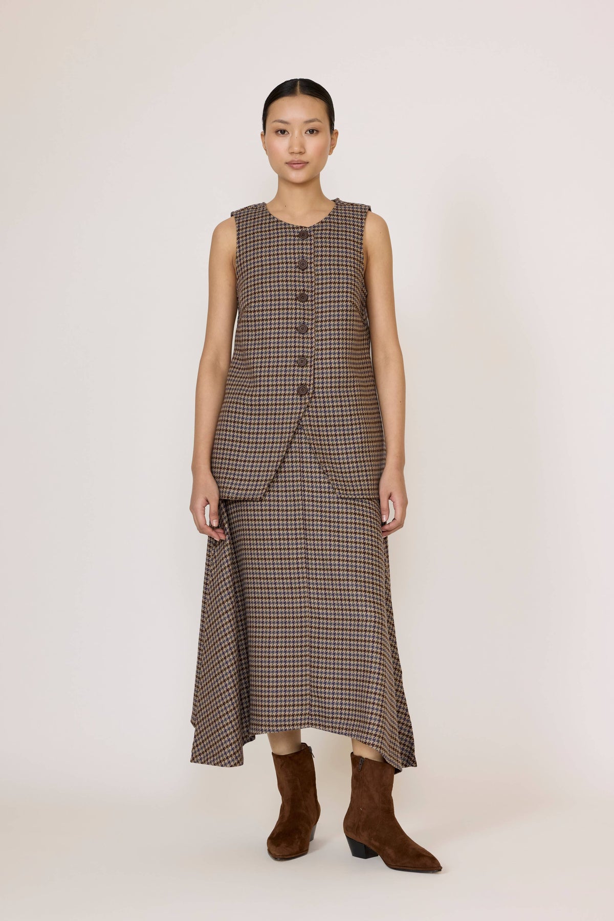 LAUDE wool plaid flowy midi skirt with pleats, showcasing its soft fabric and stylish design in a natural pose.