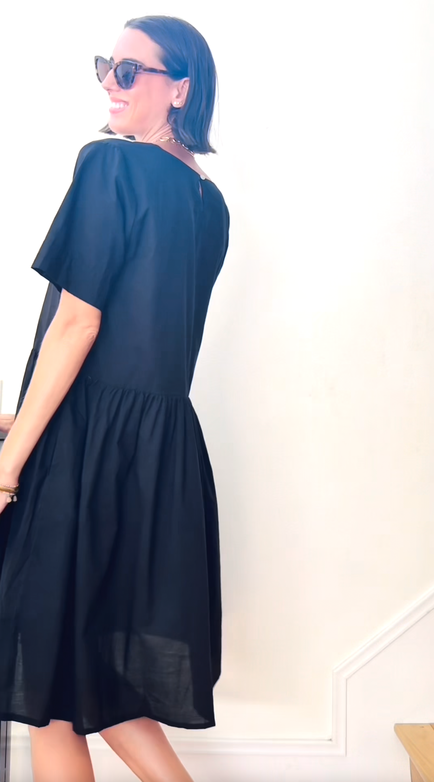 Black Hudson Dress by and for Good featuring a fitted silhouette and elegant neckline, displayed on a mannequin.
