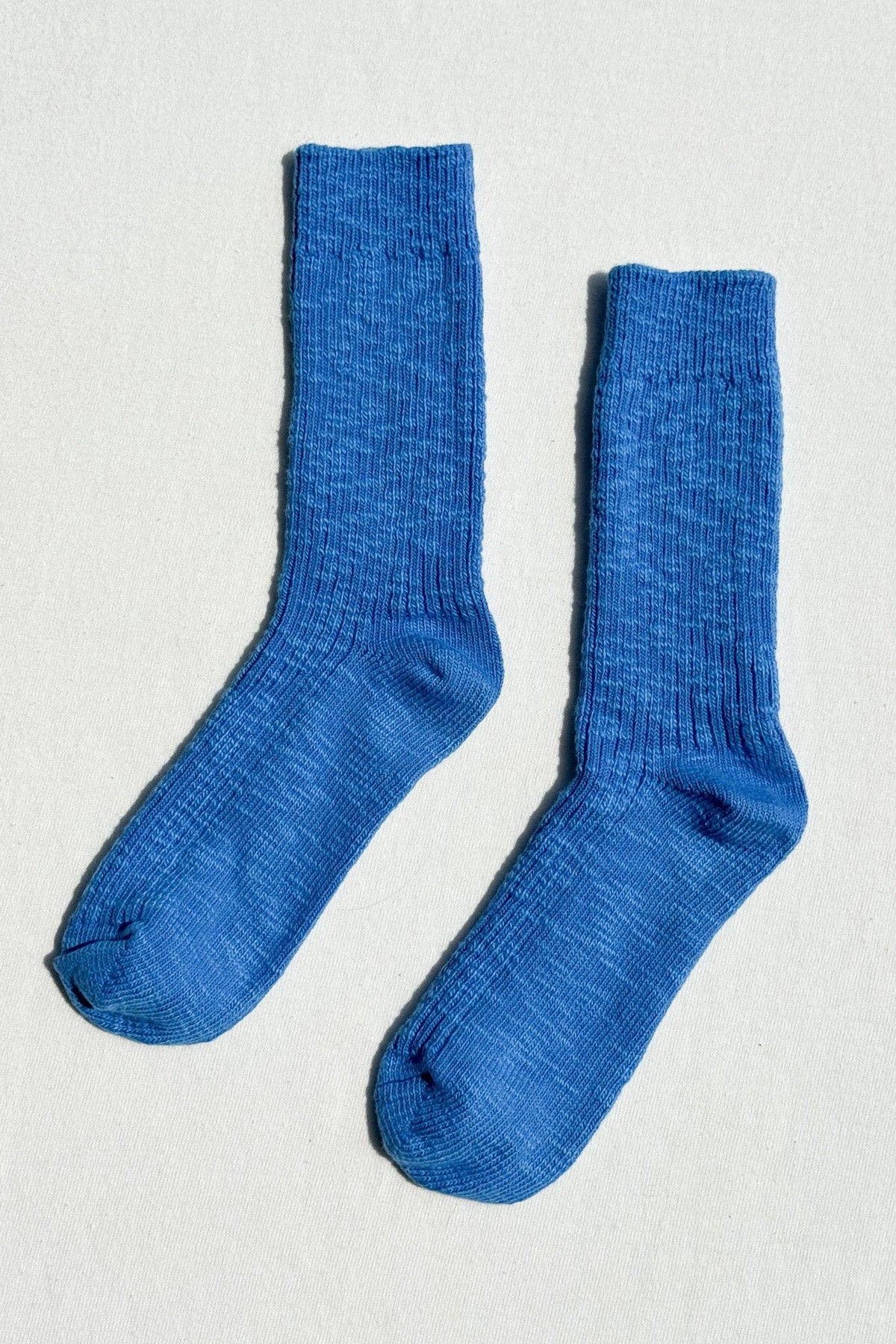 Pair of cozy Cottage Socks by Le Bon Shoppe in soft pastel colors, displayed on a neutral background.