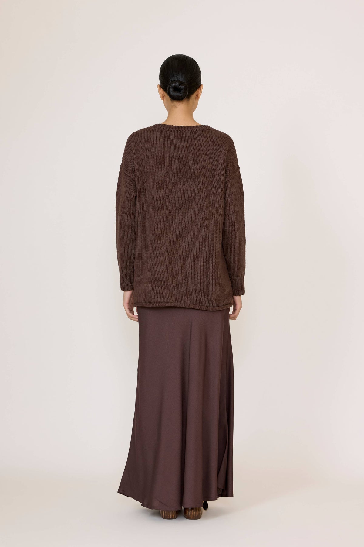 LAUDE oversized chocolate crewneck sweater displayed on a hanger, soft knit fabric with a relaxed fit and ribbed cuffs.