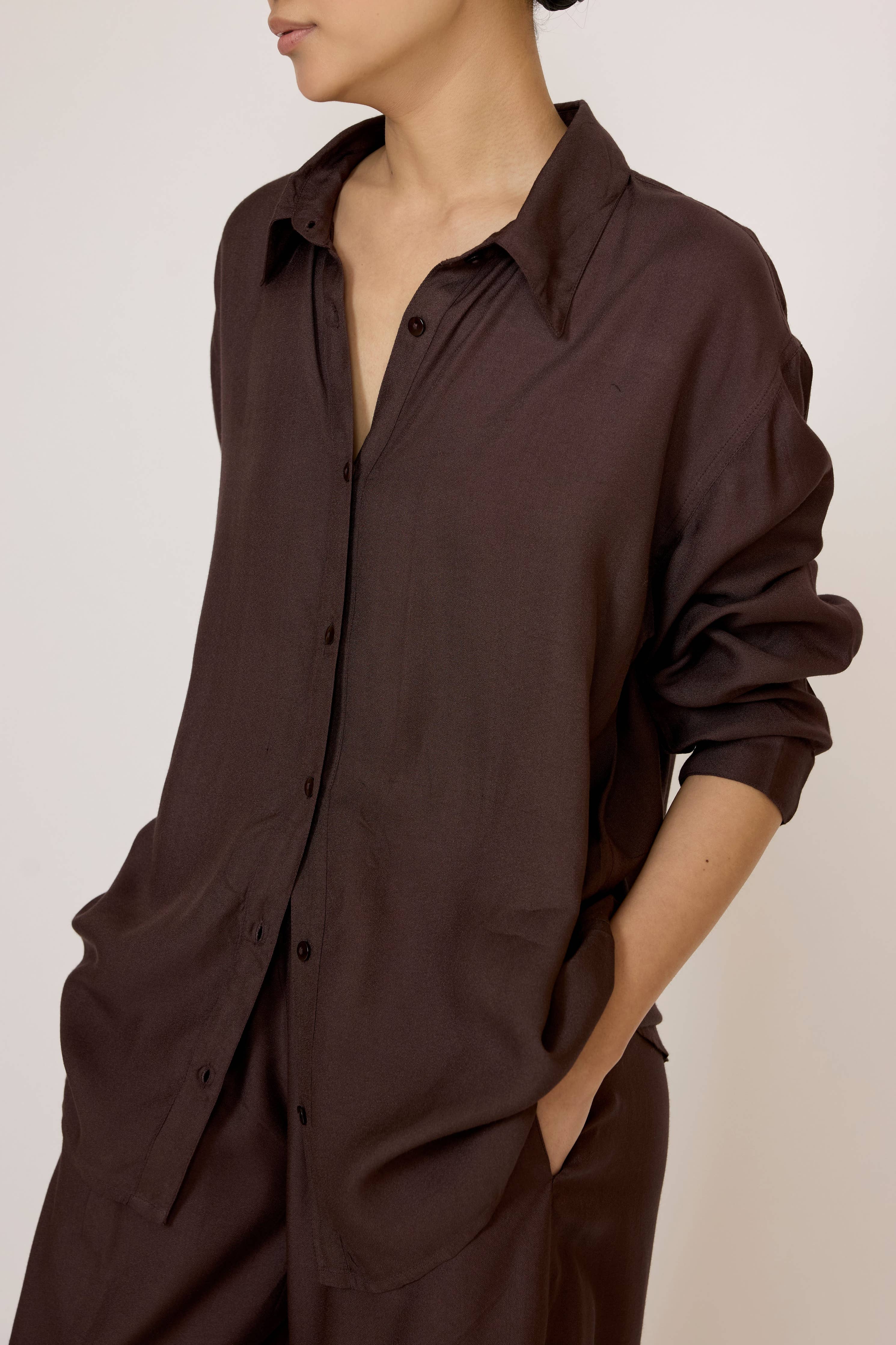 LAUDE Everything Shirt in chocolate brown, casual men's shirt with a relaxed fit and button-down front, displayed on a hanger.