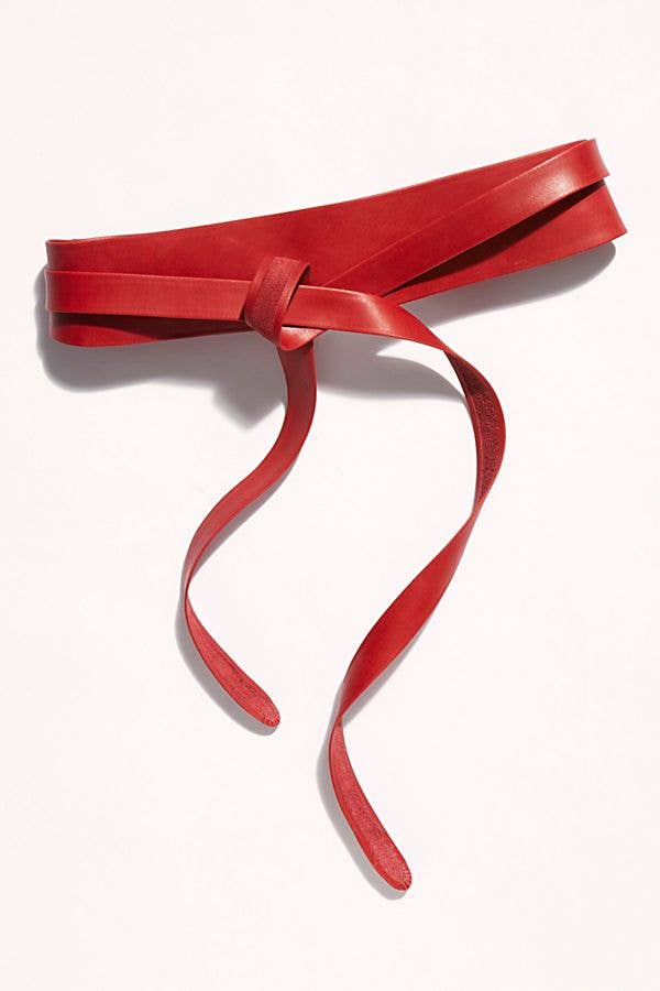 Red adjustable leather belt from ADA Collection Belts featuring a sleek wrap design and metal buckle.