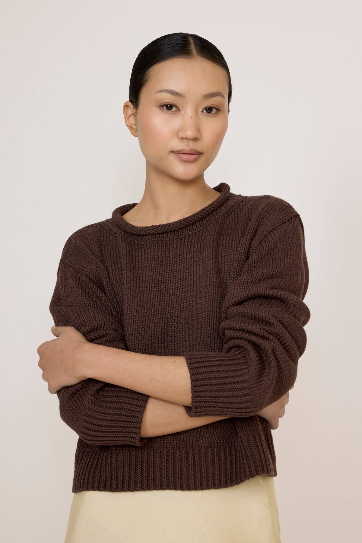 LAUDE Mare Sweater in chocolate color, cozy knit with a relaxed fit, displayed on a hanger.
