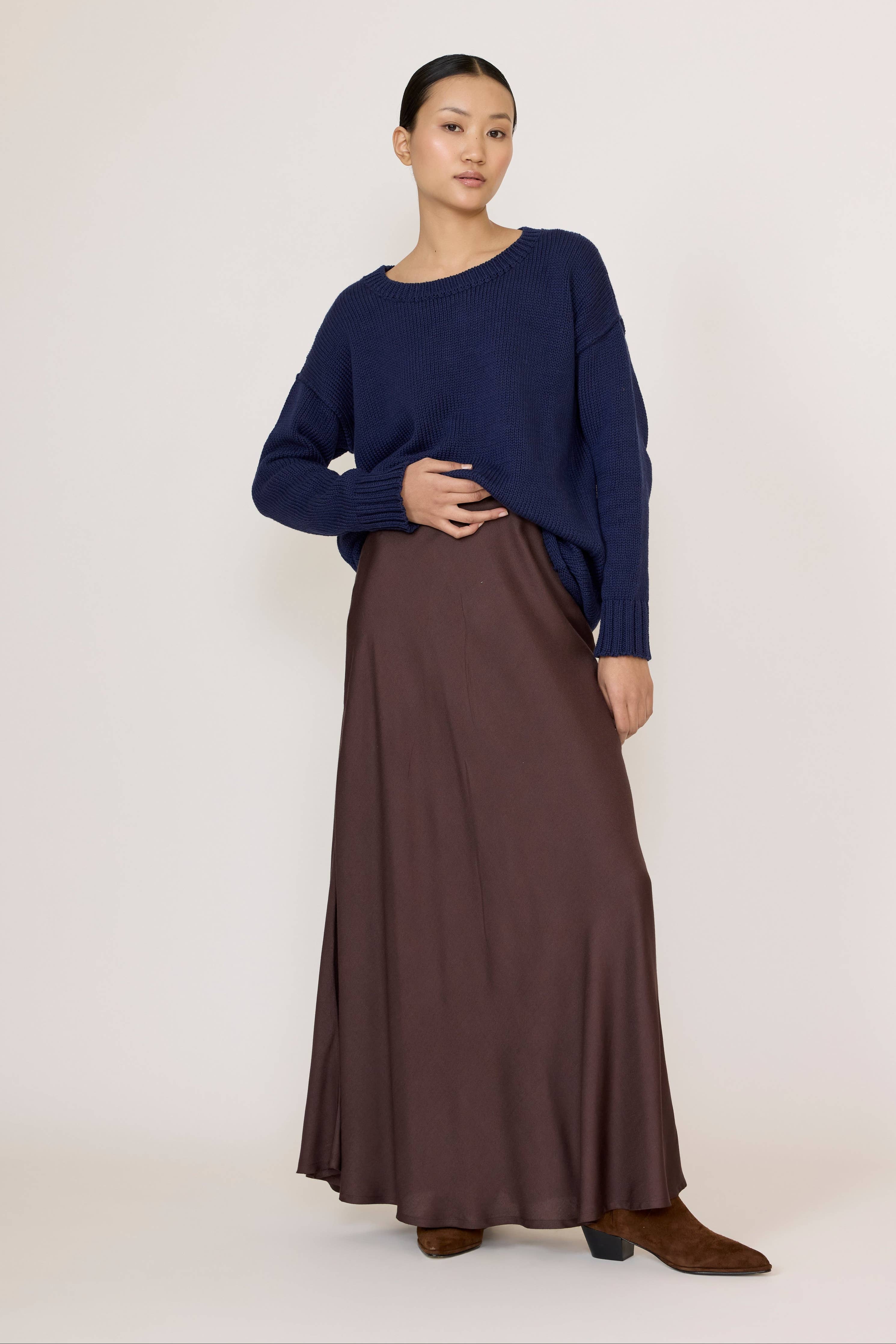 Chocolate brown bias maxi skirt by LAUDE, flowing fabric with a high waist and elegant drape, shown on a model.