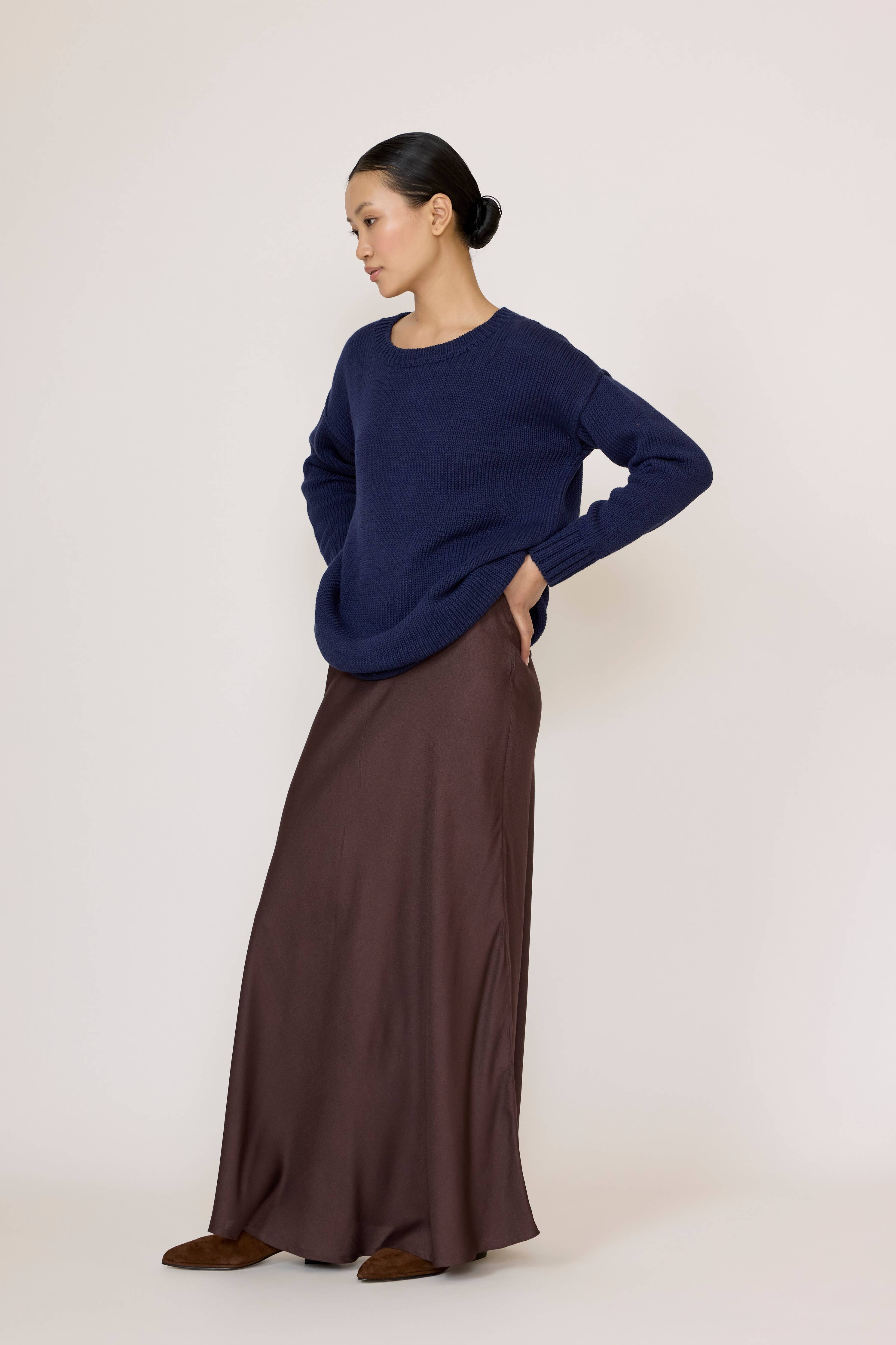 Chocolate brown bias maxi skirt by LAUDE, flowing fabric with a high waist and elegant drape in a full-length design.