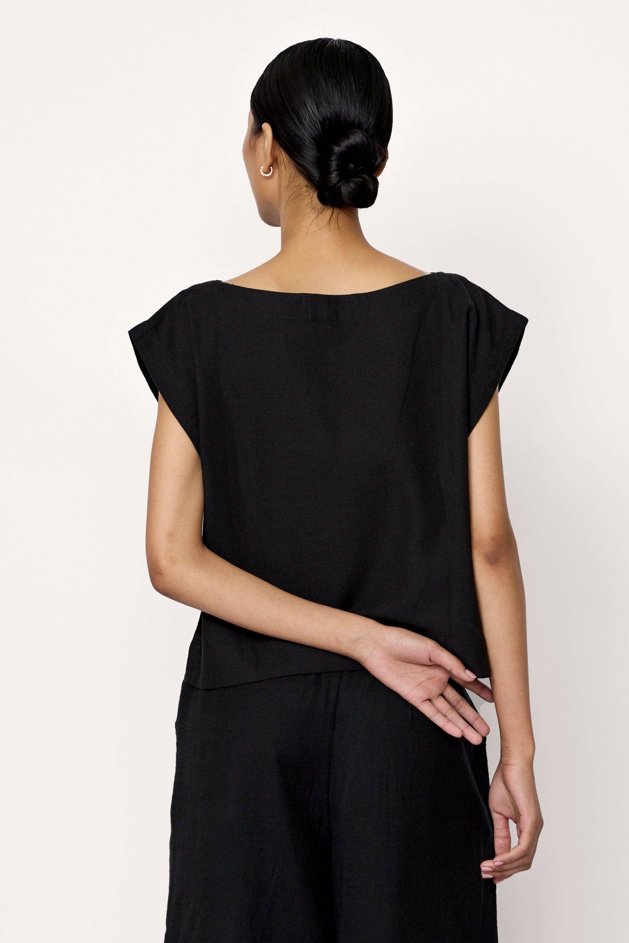 Black everyday top by LAUDE featuring a simple, comfortable design with a round neckline and long sleeves.