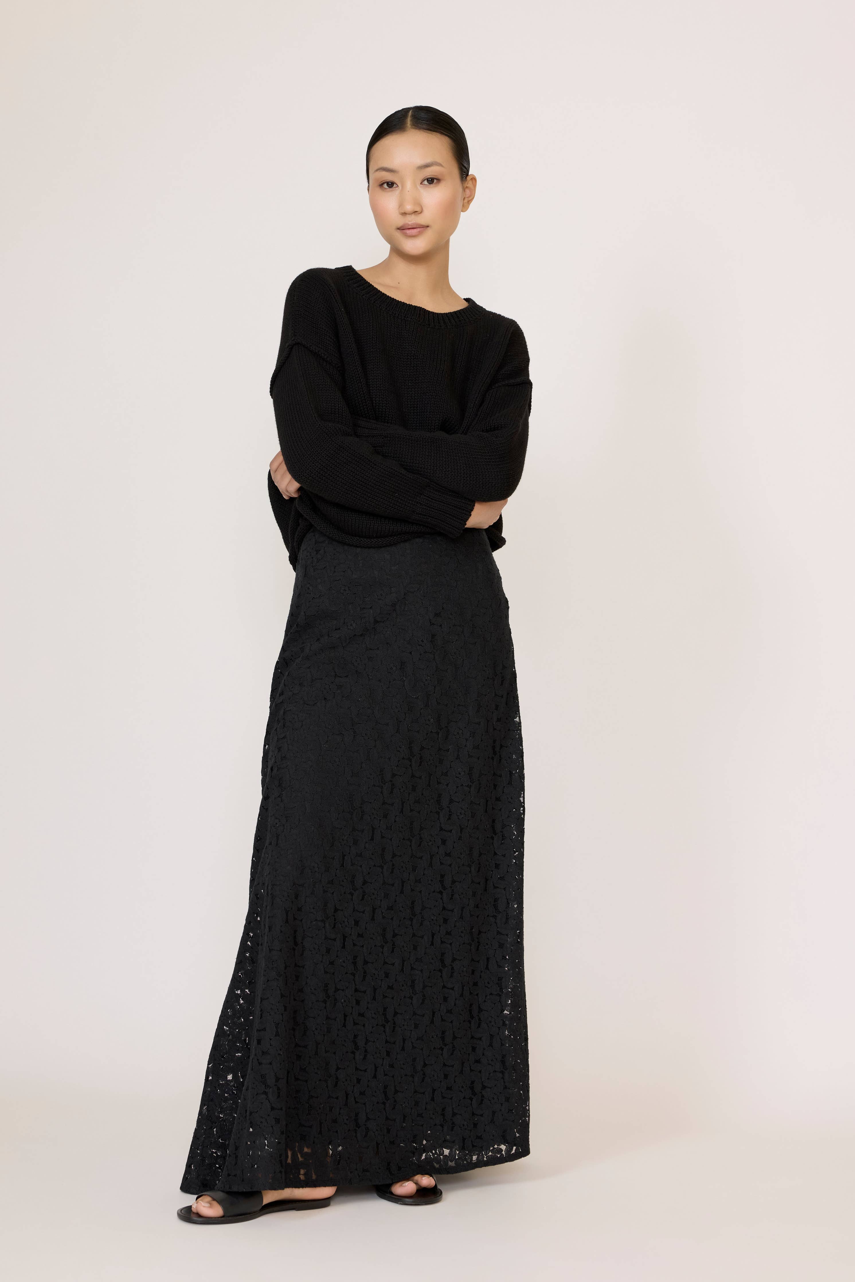 Black oversized crewneck sweater by LAUDE, showcasing a cozy, relaxed fit with soft knit fabric and classic crewneck design.