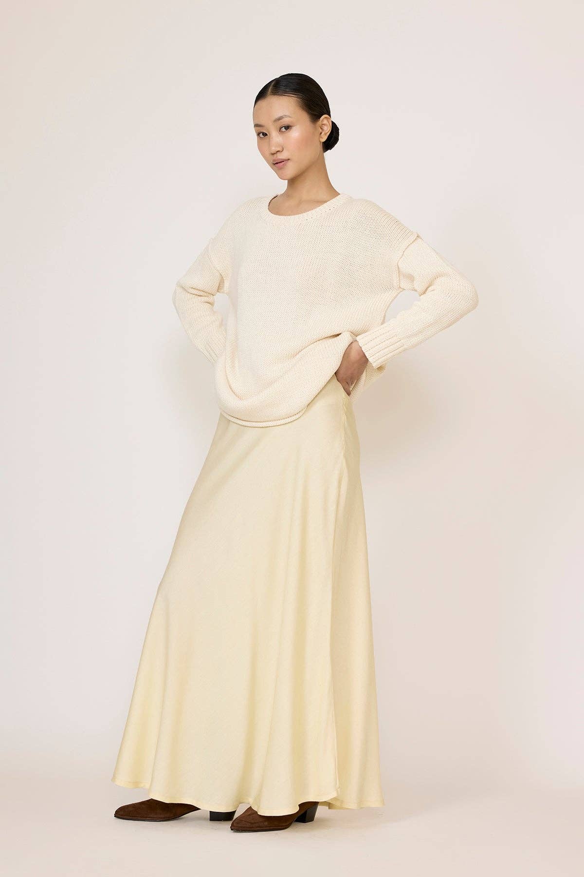 LAUDE oversized ivory crewneck sweater displayed on a hanger, showcasing its soft knit fabric and relaxed fit.