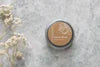 Overhead view of Vanilla Orange Refillable Hand Cream by The Village Refillery in a sleek container, highlighting its body care lotion features.